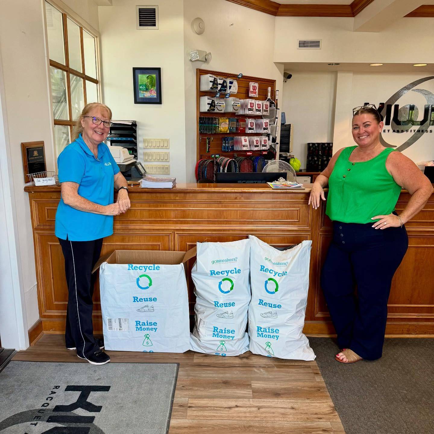 Gym staff at the front desk with full GotSneakers collection bags